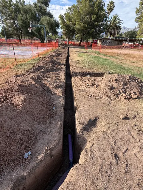 Irrigation trench cut across a park field